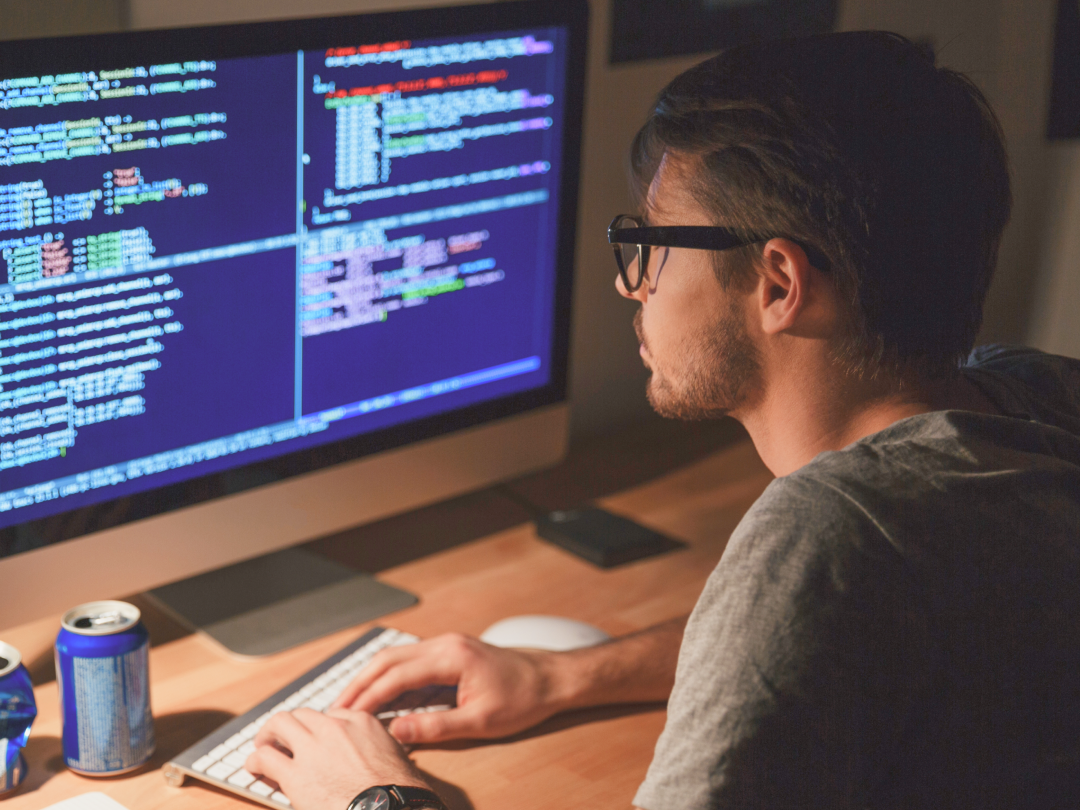 Sviluppatore NESS al lavoro davanti a monitor con codice