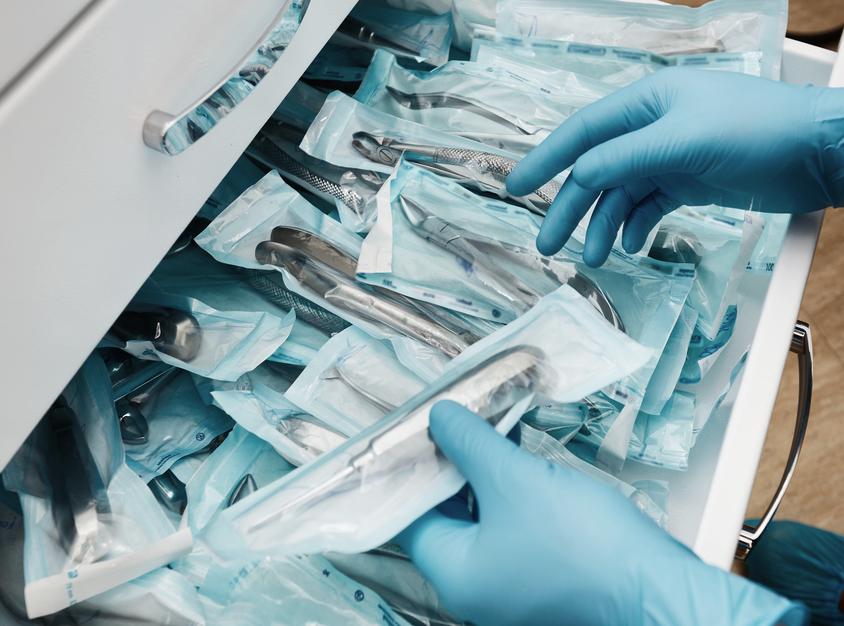 Operatore cerca strumento sterilizzato e impacchettato all'interno di un cassetto ( particolare ).